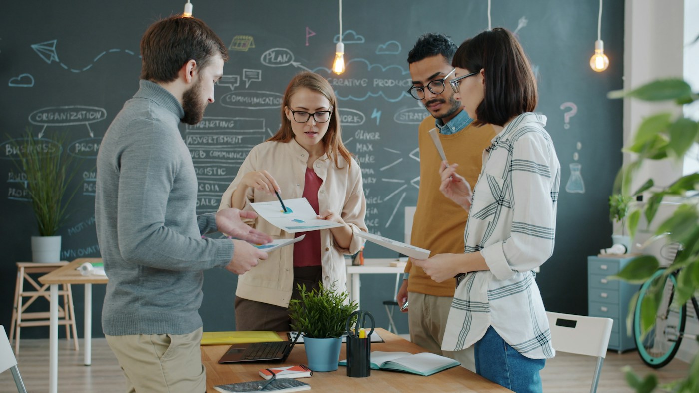 Equipo creativo colaborando alrededor de una mesa